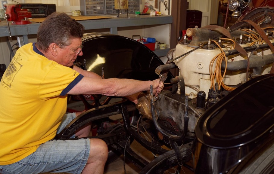 Lewis is working on reattaching the water pump.